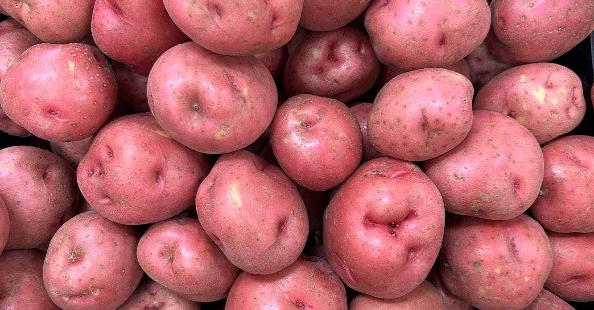 Fresh pile of red potatoes on display at a market, showcasing their natural texture and vibrant color.